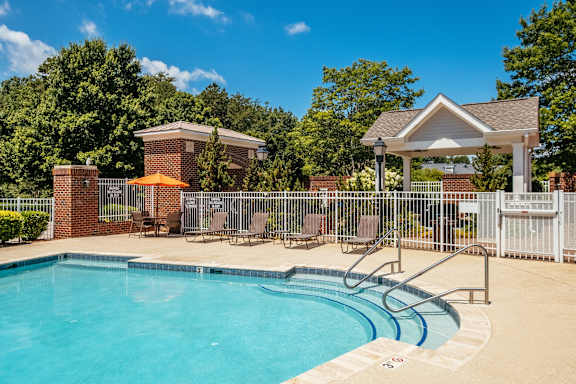 A pool with a slide and a gazebo in the background.