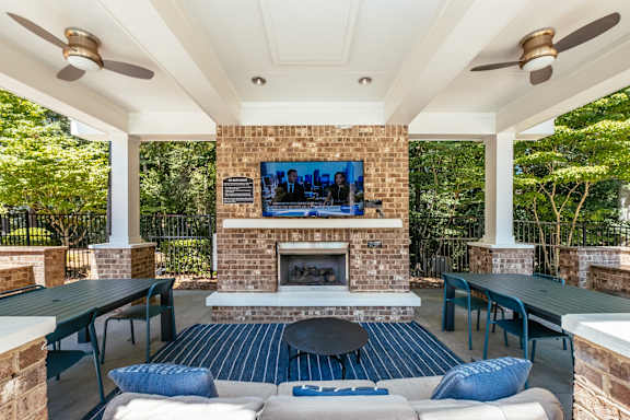A patio with a fireplace and a TV mounted on the wall.