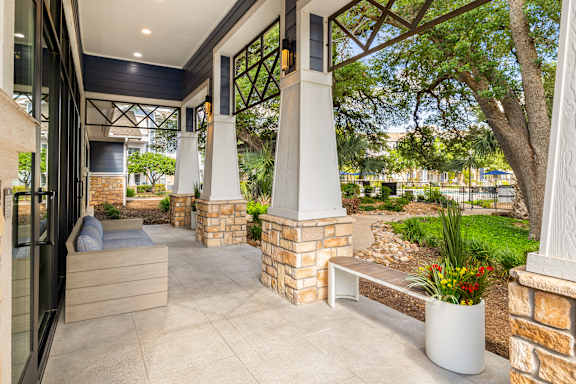 A porch with a bench and a pillar.