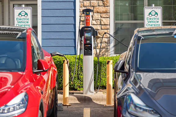 Two cars are parked at an electric vehicle charging station.