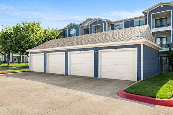 A two-car garage in front of a blue house.