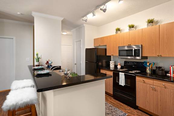 A kitchen with a black countertop and white walls.