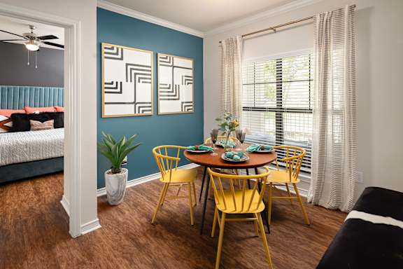 A dining room with a table set for four.