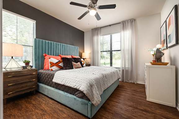A bedroom with a bed, nightstand, and a ceiling fan.