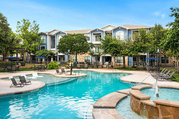 A swimming pool with a fountain in the middle of it.