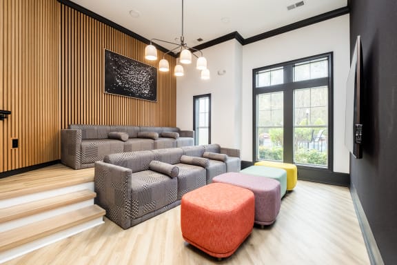 a living room with couches and stools and a large window