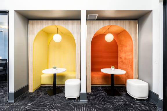 a meeting room with two tables and a yellow and orange wall