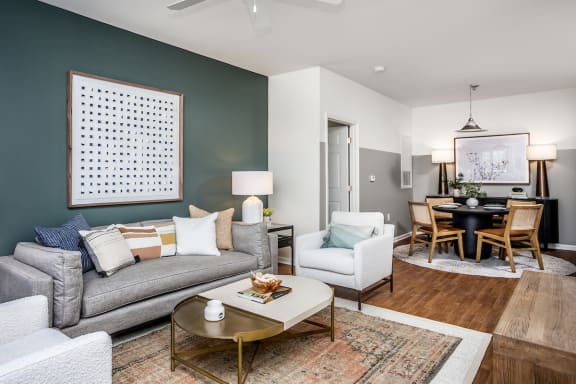 a living room and dining room with a couch and chairs and a table with a chair and