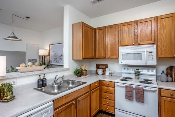 a kitchen with white appliances and wooden cabinets