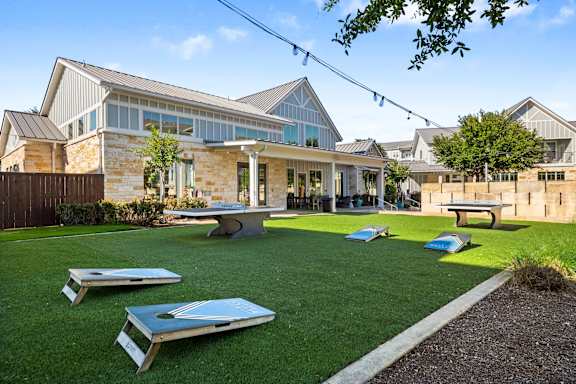 A backyard with a lawn and a building in the background.
