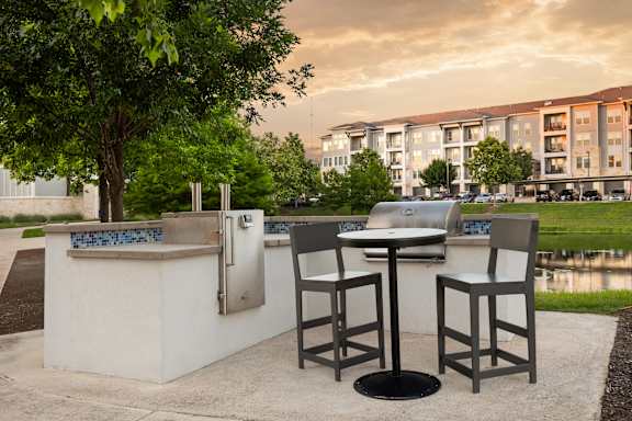 A table and two chairs are set up outside in front of a building.