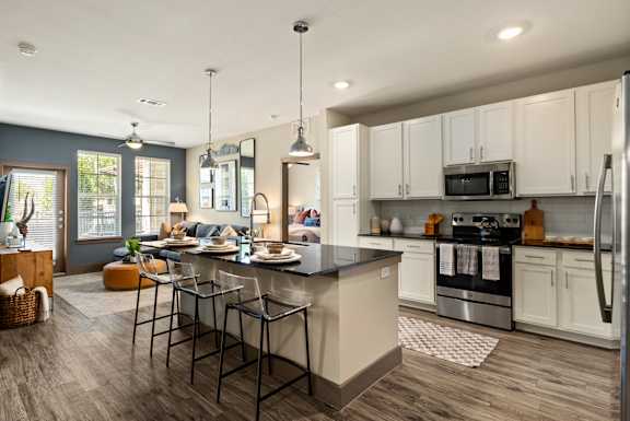 A modern kitchen with a large island and stainless steel appliances.