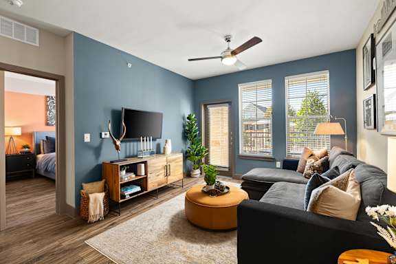 A living room with a black couch and a television.