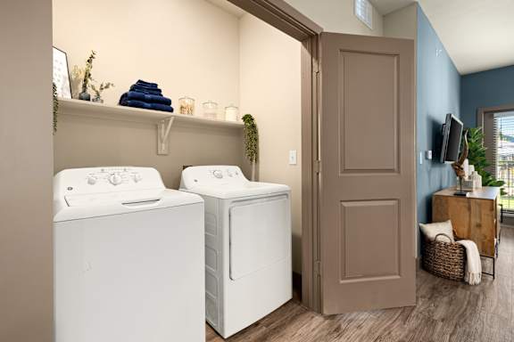 Two white front loading washing machines in a laundry room.