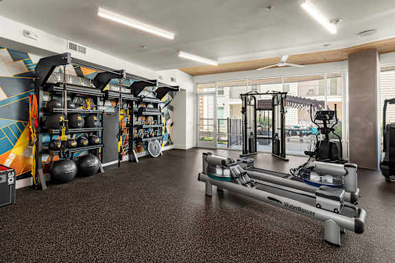 A gym with a variety of equipment including a rowing machine.