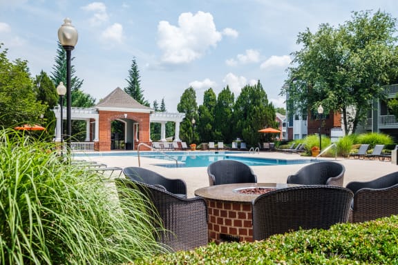 a swimming pool with chairs and a poolside table