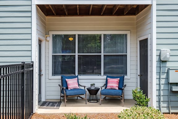 A small porch with two chairs and a table.