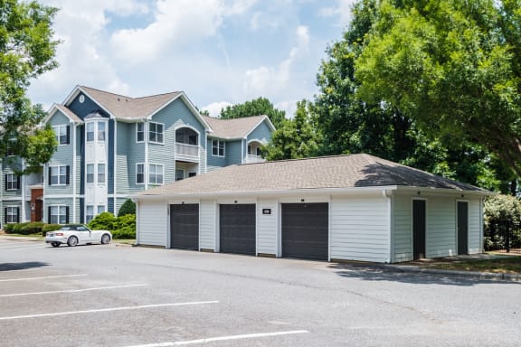 a garage with two roll up garage doors in front of an apartment building