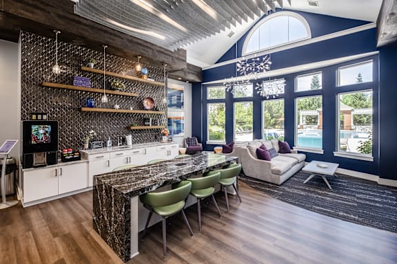A kitchen with a marble countertop and a dining table with chairs.
