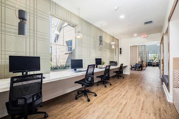 A long, narrow office space with wood floors and white walls.