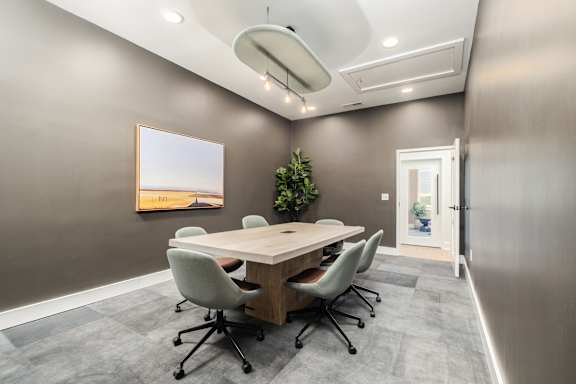 A conference room with a long table and chairs.