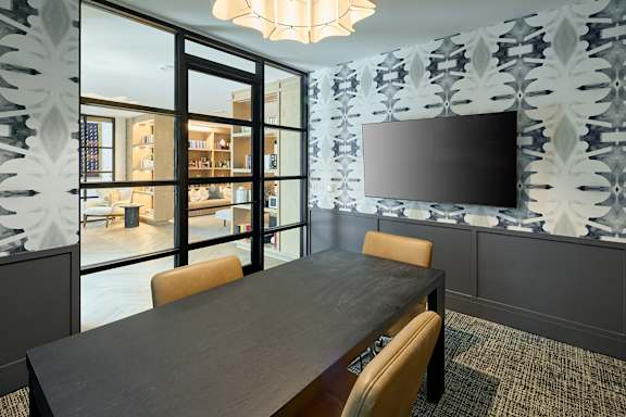 A modern dining room with a large table and chairs.