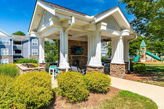 A white porch with a white roof and four white columns.