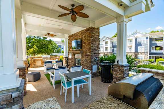 A patio with a table and chairs under a ceiling fan.