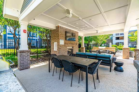 A patio with a table and chairs under a roof.