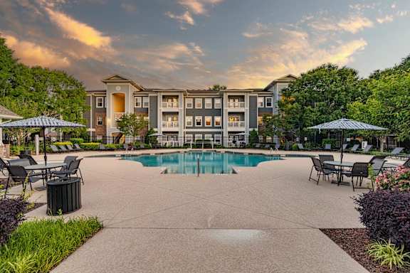 A large building with a pool in front of it.