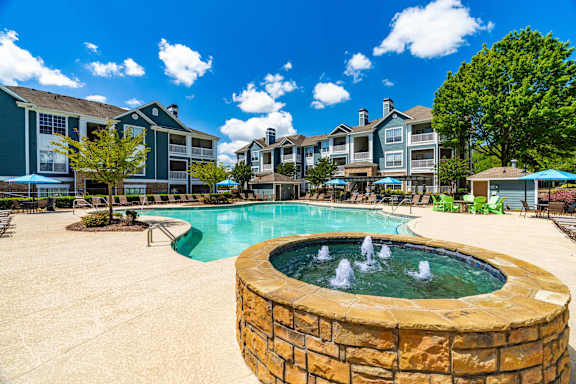 A pool with a fountain in the middle of it.