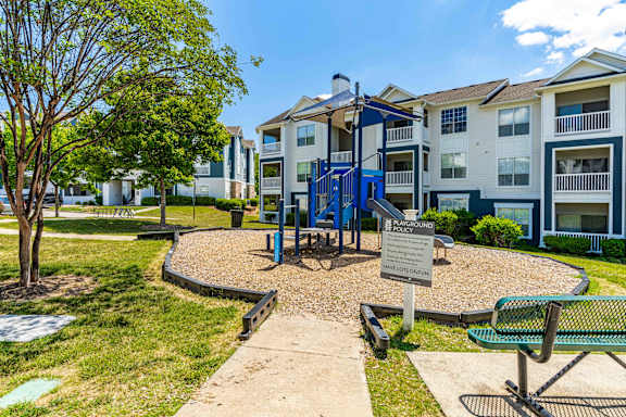 A playground area in front of a residential building.
