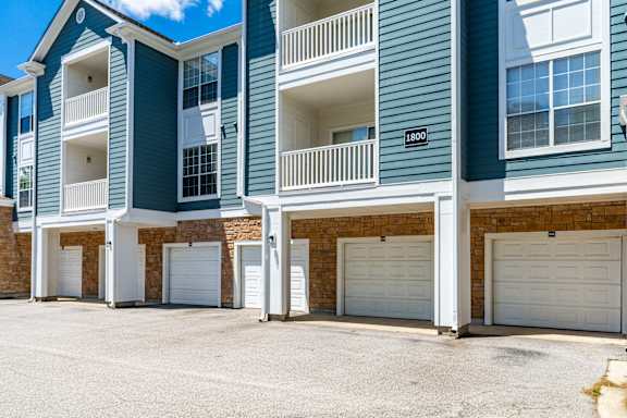A row of townhouses with garages and balconies.