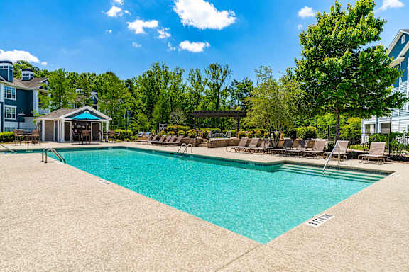 A swimming pool with a pavilion and sun loungers.