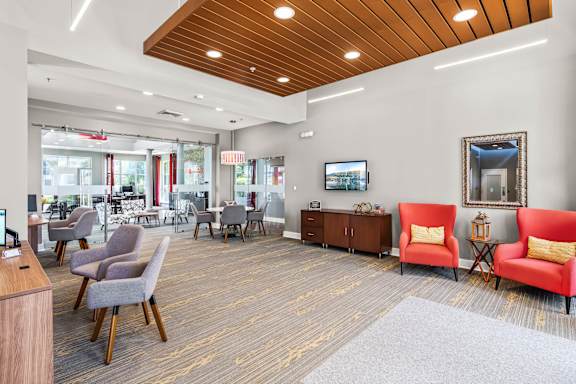 A waiting room with a red chair and a television.