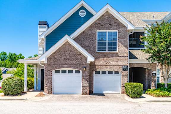 A two-story house with a garage and a driveway.
