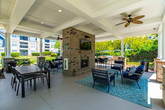A patio with a table, chairs, and a fireplace.