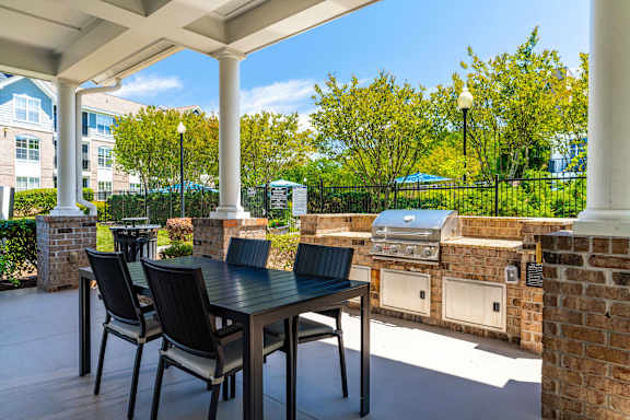 A patio with a table and chairs under a white roof.