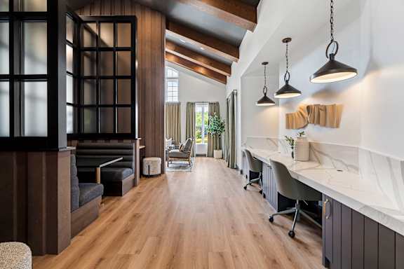 A modern office space with wood floors and a long table.