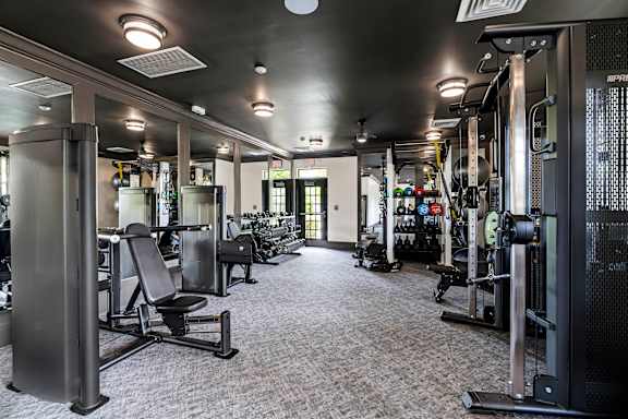 A gym with a variety of equipment including weights and machines.