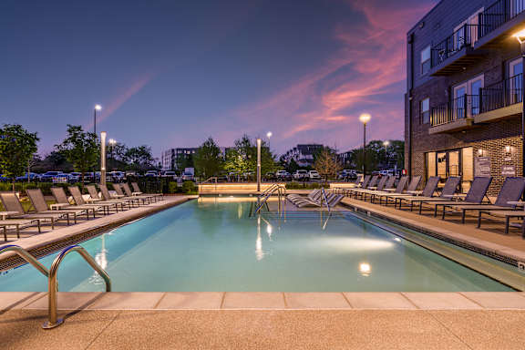 A large outdoor swimming pool surrounded by lounge chairs.