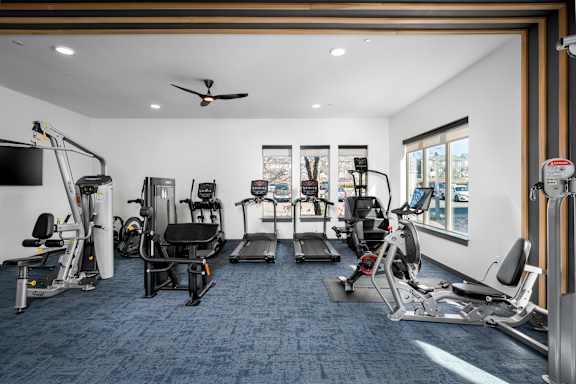 A spacious gym with a variety of equipment including treadmills, weights, and exercise machines.