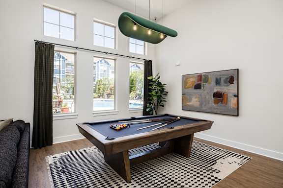 A pool table in a room with a painting on the wall.