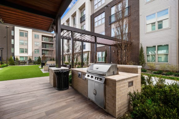 an outdoor kitchen with a grill on a wooden deck