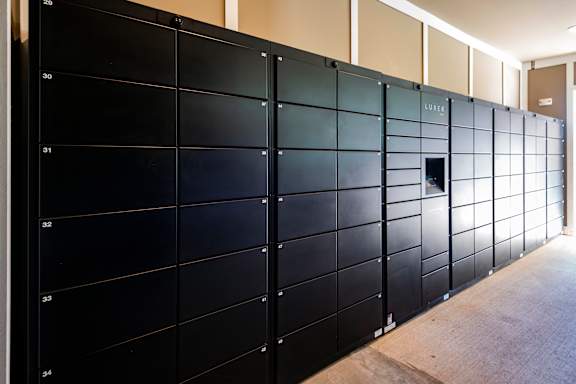 A wall of black lockers with numbers on them.