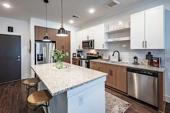 A kitchen with a granite countertop and stainless steel appliances.