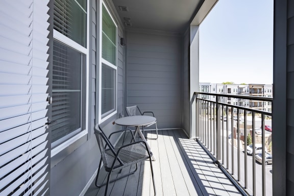 a small table and two chairs sit on a balcony in a 555 waverly unit