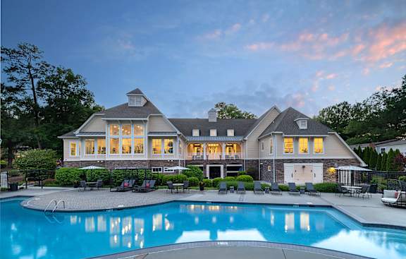 A large house with a pool in front.