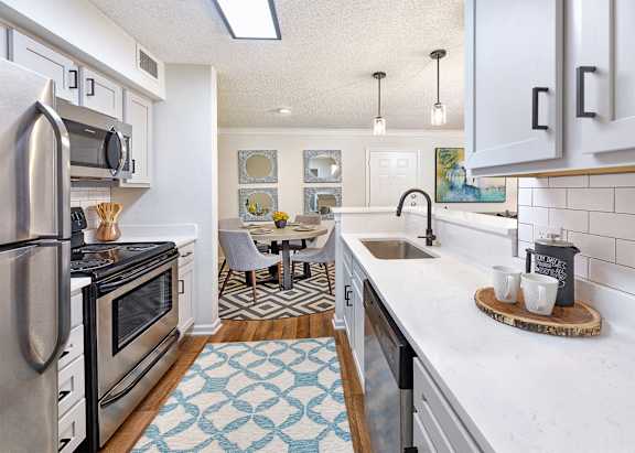 A kitchen with a refrigerator, microwave, and oven.