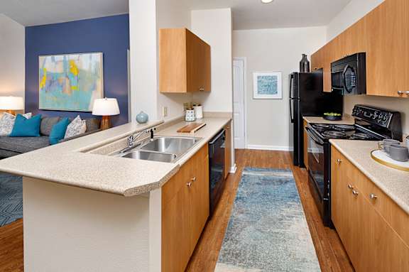 A kitchen with a white counter top and wooden cabinets.